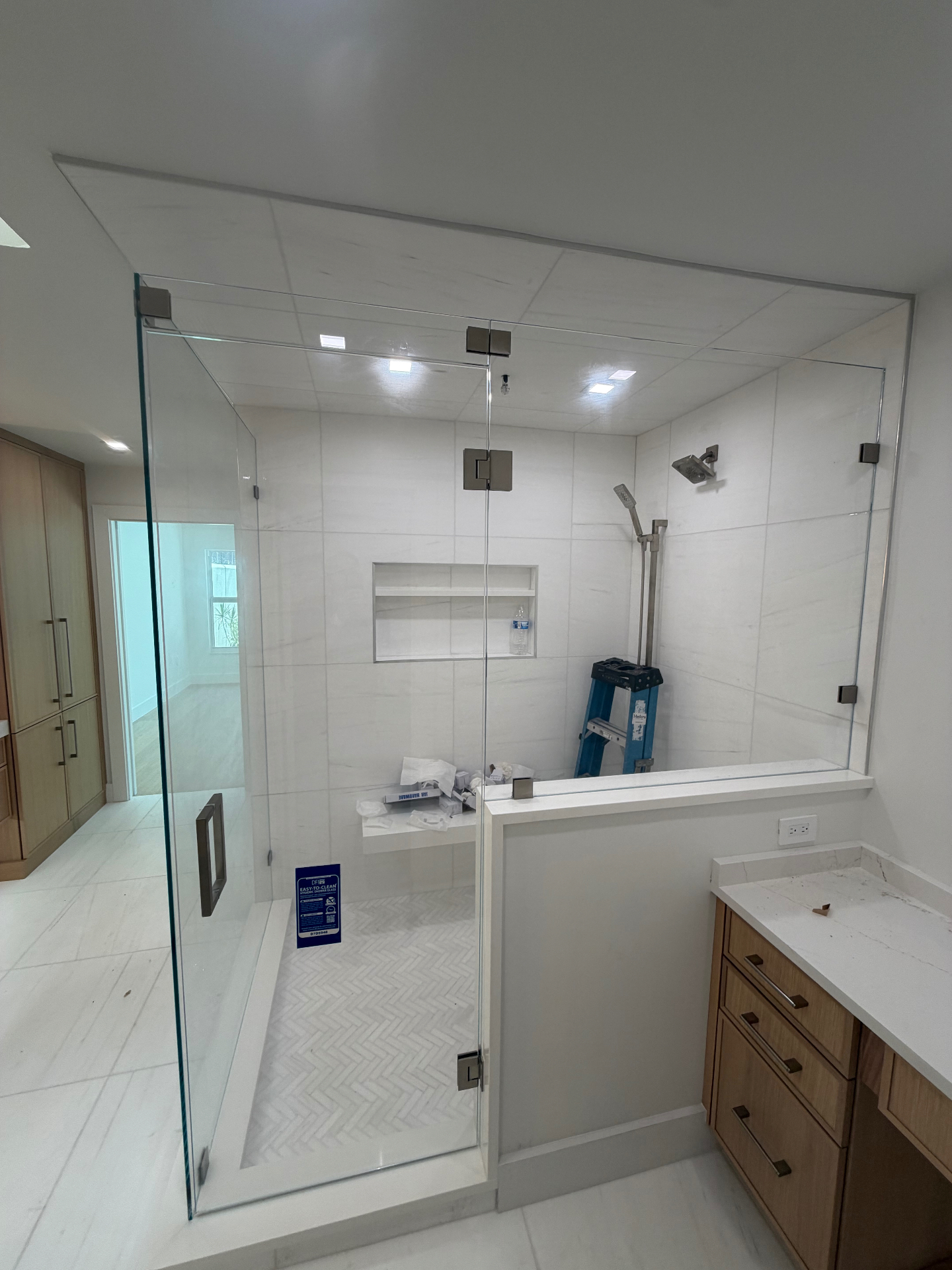 Frameless walk-in shower enclosure with brushed nickel hardware — Cape Coral install
