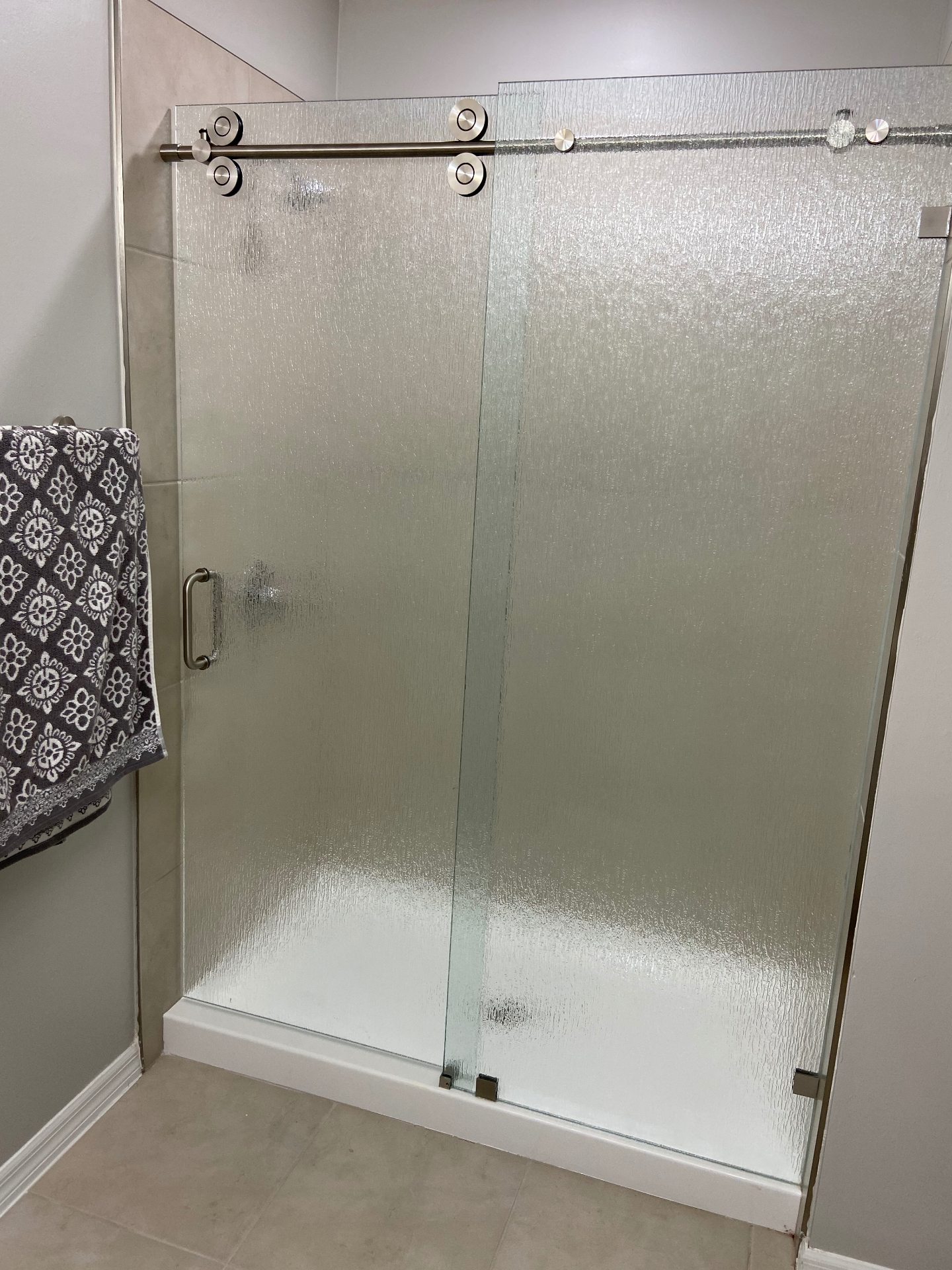 Sliding shower door with rain glass and brushed nickel hardware — Fort Myers install